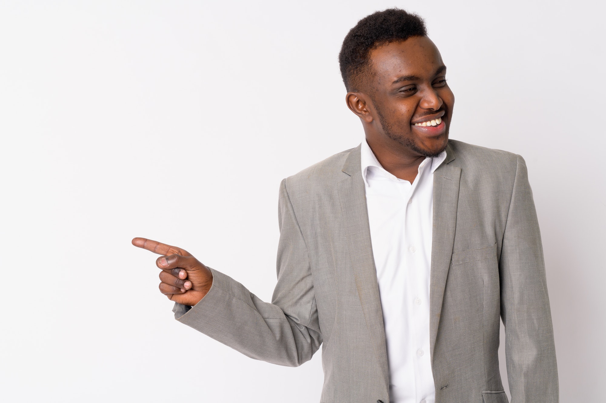 Portrait of happy young African businessman laughing and pointing finger